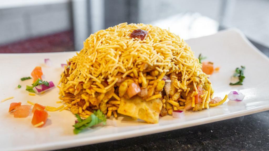 Bhel Puri · crispy rice puffs tossed with chopped onion, tomatoes, mint and tamarind chutney, sprinkled with chickpea noodles.