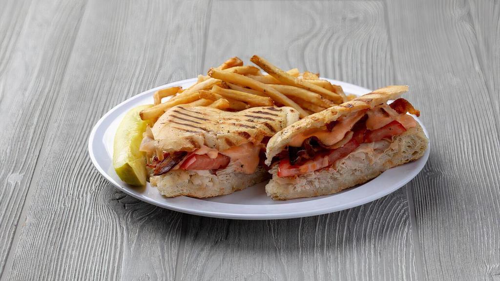 Culture Club · Our turkey club panini with turkey, bacon, Swiss cheese and tomato, grilled to a golden brown and served with homemade red pepper mayo on the side. Served with French Fries.