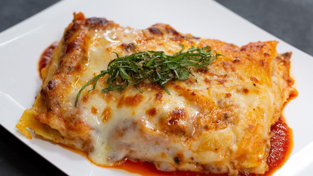 Lasagna Emiliana · Oven baked homemade pasta layered with Bolognese ragu and parmesan béchamel
