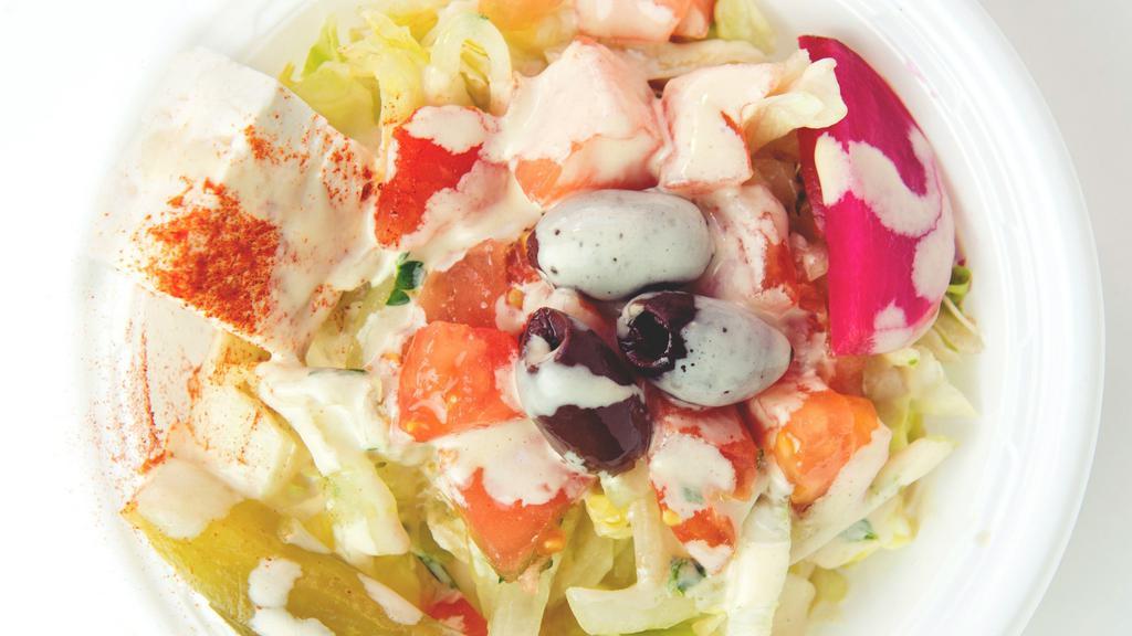 Mamoun'S Salad · Lettuce, tomatoes, onions, pickles, turnips, olives, feta cheese, grape leave, lemon juice, olive oil, and tahineh sauce.