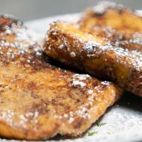 French Toast · Two slices of thick texas toast topped with powdered sugar.