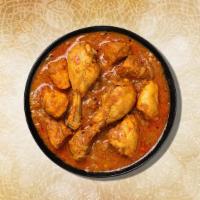 Chicken Curry · Chicken pieces simmered with jeera, turmeric, and red chili powder cooked with tomatoes with...