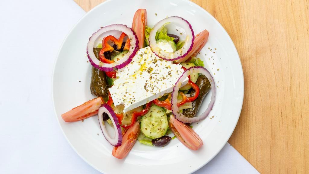 Classic Greek Salad · Lettuce, tomatoes, feta cheese, kalamata olives, peppers, onions and stuffed grape leaves.
