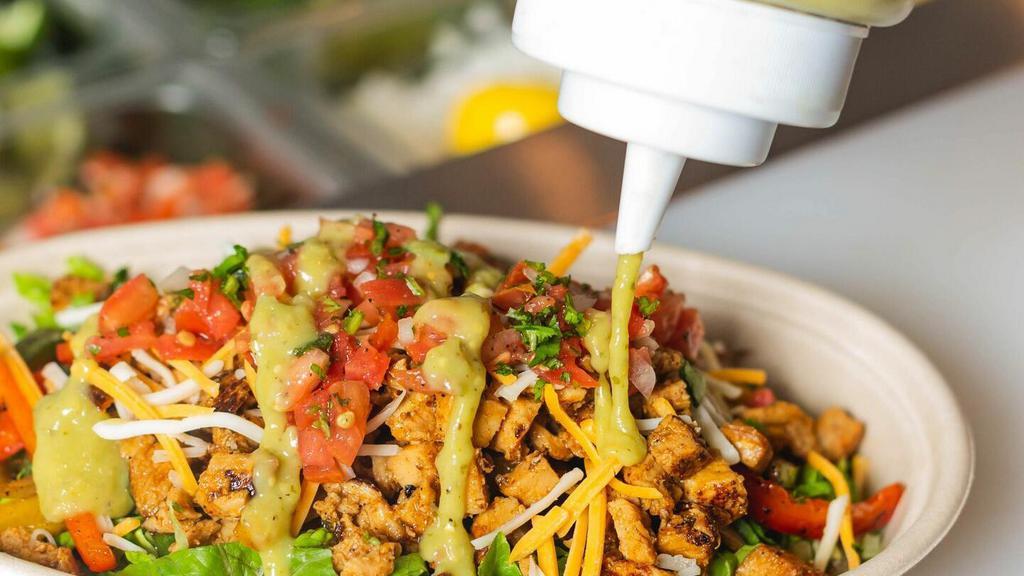 Carnitas Fajita Bowl · OUR FAMILY RECIPE! TENDER, SLOW-ROASTED, THREE-CHILE PORK - Served rice or lettuce. Topped with fajita peppers and onions, black beans, cheese, pico, tomatillo salsa, crema. Served with two corn tortillas