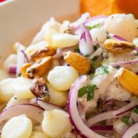 Ceviche De Pescado · Raw fresh fish marinated in lime juice served with onions, sweet potato, and Peruvian corn.