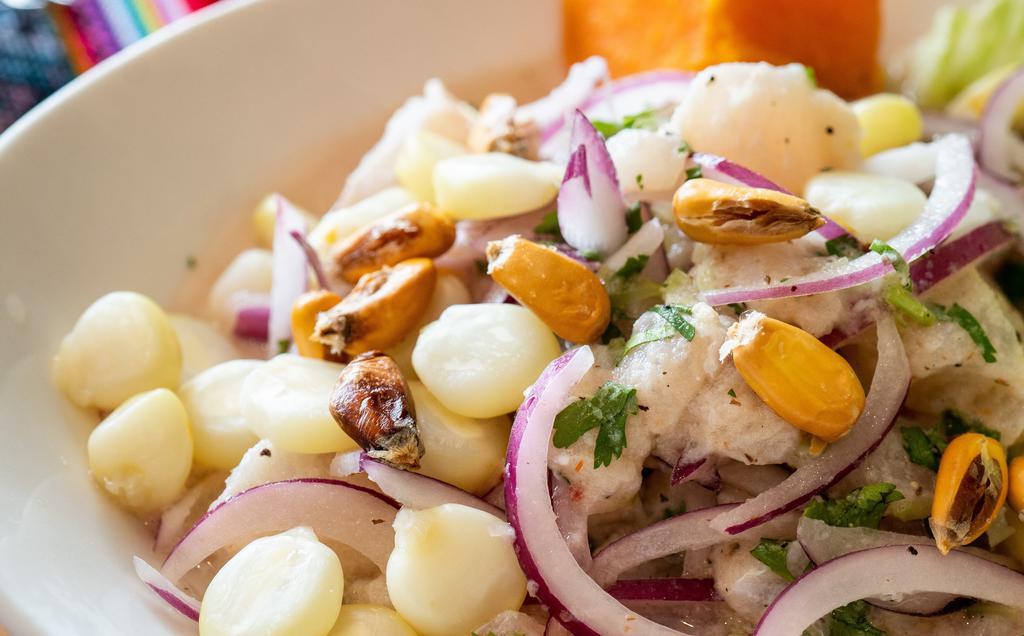 Ceviche De Pescado · Raw fresh fish marinated in lime juice served with onions, sweet potato, and Peruvian corn.
