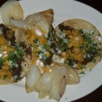 Chicken Tacos · Three chicken tacos with onion cilantro and guacamole.