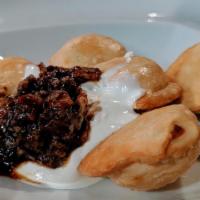 Pierogies · Fried cheese and potato dumplings topped with sour cream, house made bourbon-bacon jam and g...