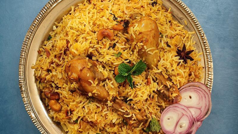 Peshawari Chicken Biryani · Our long grain basmati rice cooked with chicken marinated in yogurt and house spices fresh vegetables and chicken in our special biryani masala gravy, served with a side of yogurt raita