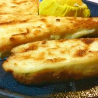 Three Cheese Saganaki · Kefalograviera, feta and haloumi cheeses, lemon juice and metaxa.