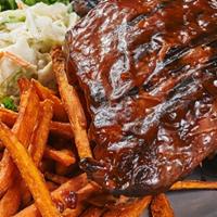 Baby Back Ribs · Ribs smothered in our house made Jack Daniels BBQ sauce, served with sweet fries and coleslaw