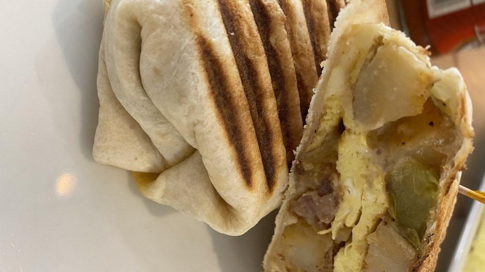 Breakfast Burrito · Two eggs, choice of potato, meat and cheese grilled and served in a white or wheat wrap.