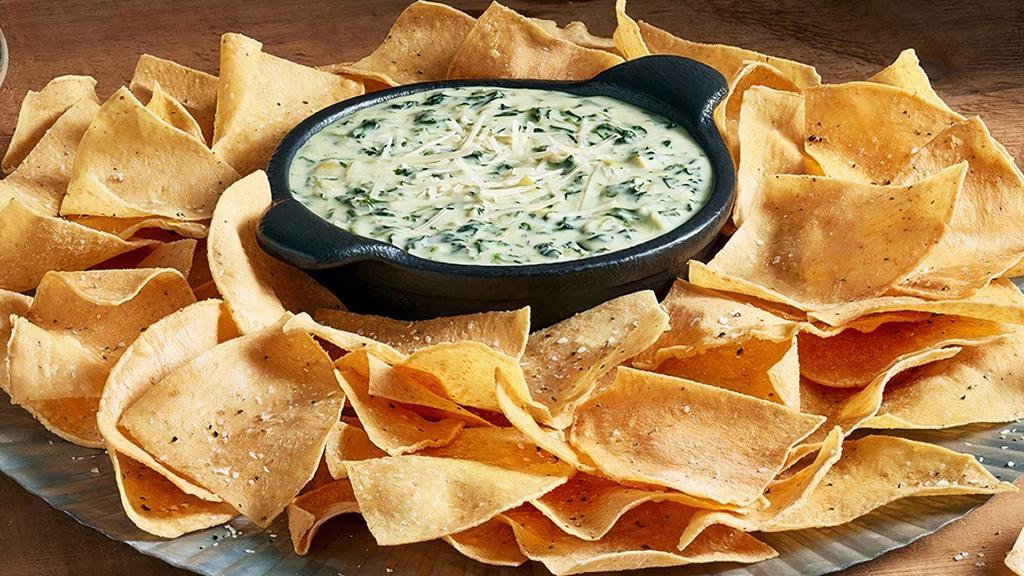 Spinach Artichoke Dip · Made with tender artichoke hearts and shredded Parmesan cheese. Served with tortilla chips.