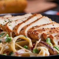 Chicken Carbonara · Grilled chicken served atop fettuccine tossed with Parmesan cream, bacon, peas, roasted baby...