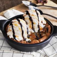 Chocolate Chip Cookie Skillet · A freshly baked chocolate chip cookie served warm in a skillet with vanilla bean ice cream a...