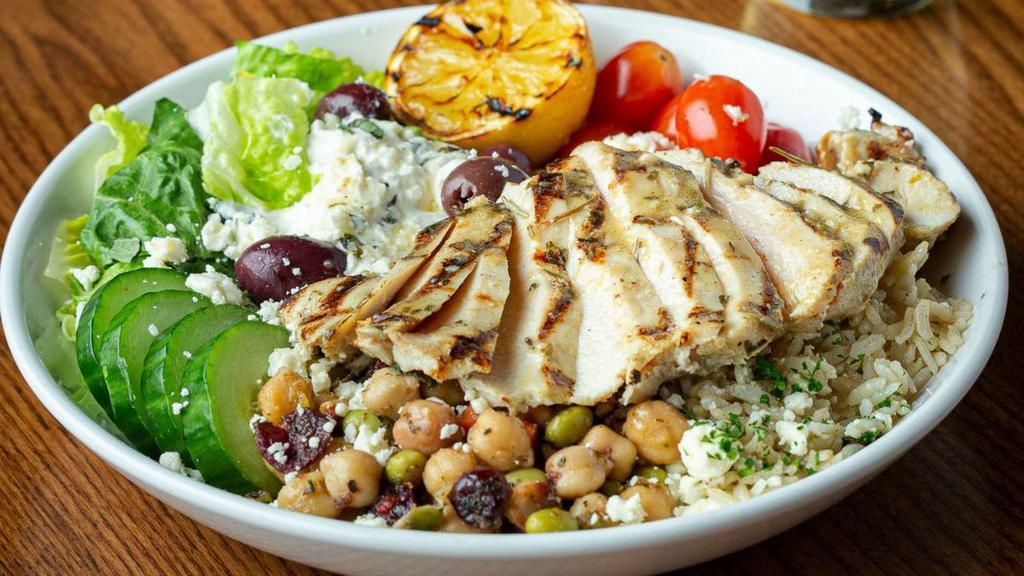 Mediterranean Chicken Bowl · A refreshing blend of Mediterranean bean salad, crisp romaine, Kalamata olives, cucumbers, tomatoes, Tzatziki and steamed brown rice. Topped with fresh oregano, feta cheese, fresh grilled lemon and lemon rosemary chicken.