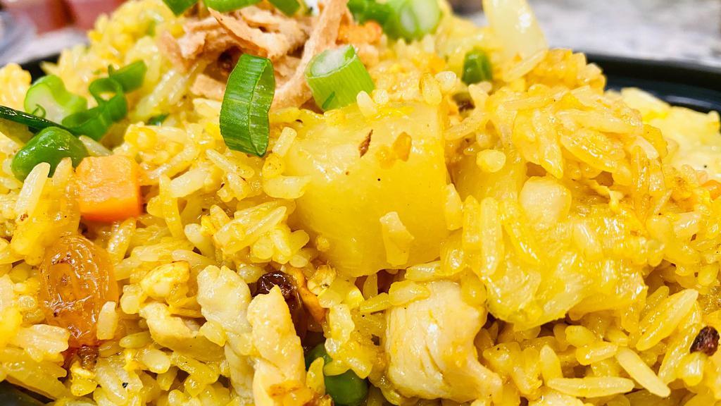 Pineapple Fried Rice · Flavorful fried rice with pineapple, cashew nuts, onion, tomato, scallion, raisins, peas, carrot, and egg.