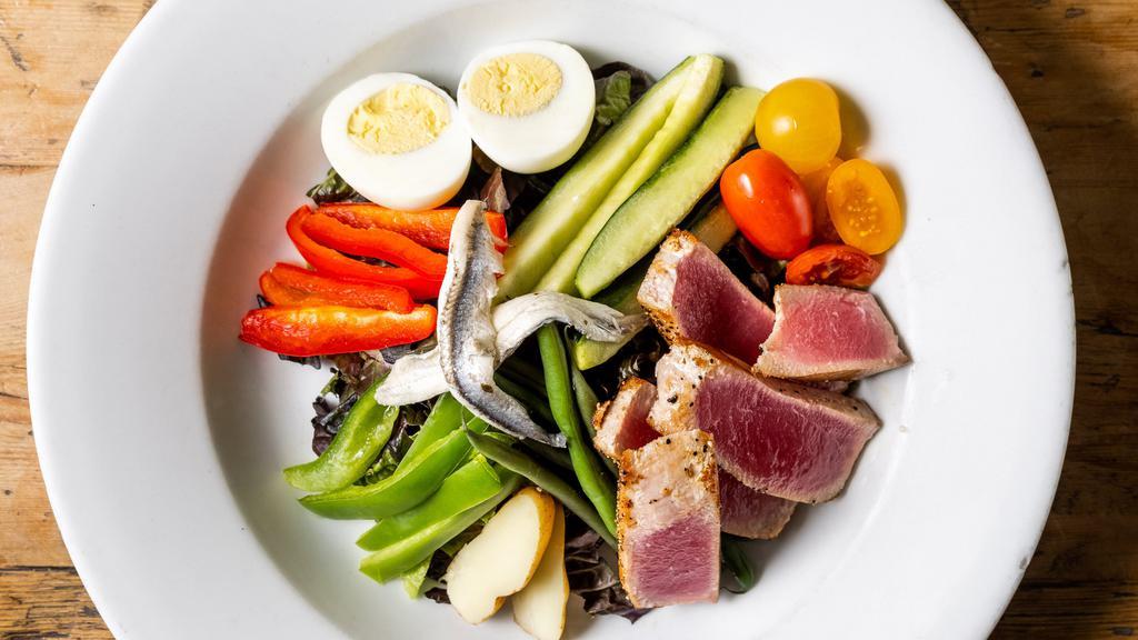 Niçoise Salade · Grilled tuna steak, bib butter lettuce, hard boiled eggs, anchovies, haricots vert, grilled vegetables, boiled fingerling potatoes, julienne of peppers and artisanal olives.