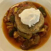 Oeuf Gamin · Poached egg in a mixed herbs potato goat cheese nest on a bed of thick slow cooked ratatouil...