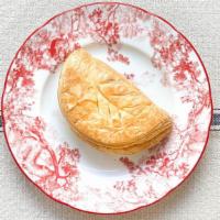 Chausson Aux Pommes · Puff pastry filled with apples and cinnamon sugar. Golden brown and brushed with a sugar gla...