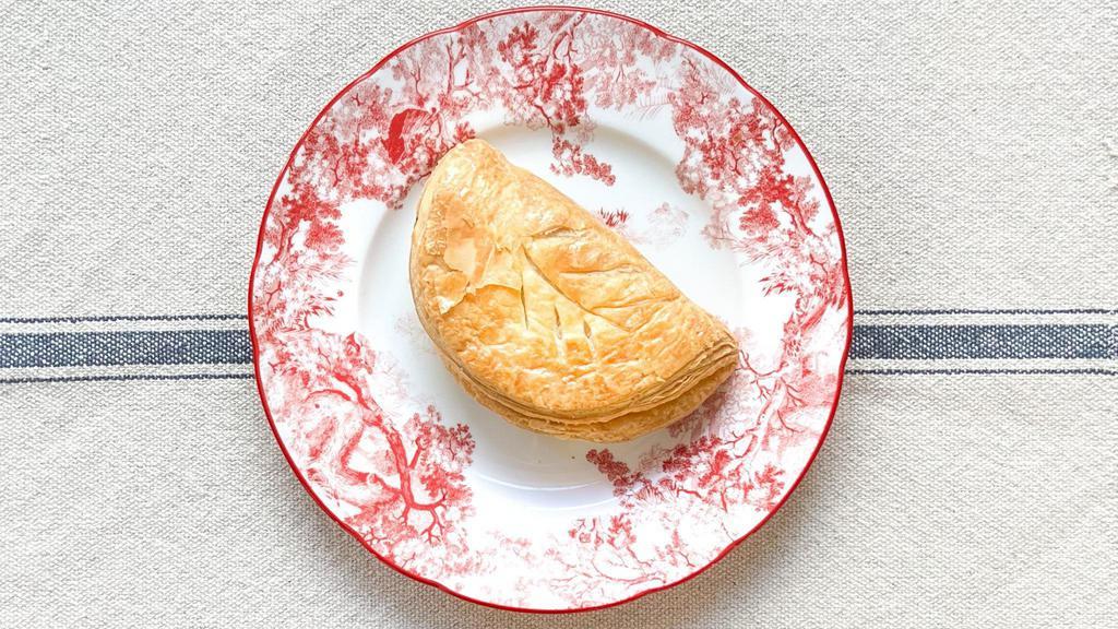 Chausson Aux Pommes · Puff pastry filled with apples and cinnamon sugar. Golden brown and brushed with a sugar glaze — Baked fresh each morning.