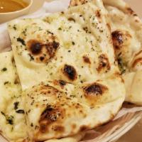 Garlic Naan · Made with white flour mix with milk & salt coated with butter & garlic cooked in charcoal ov...