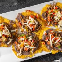 Patacones Arreglados Con Carne · Fried green plantains with meat.