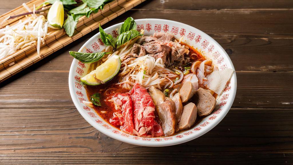 P02 . House Spicy Pho Noodle Soup / 辣味火车头 2 · Comes with Rare Eye Roud, Brisket, Tripe and Tendon, Beef balls with rice noodles, served with Spicy beef broth, onions, scallions, and lemon, basil & bean sprouts on the side.