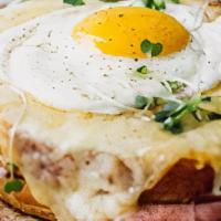 Croque Madame · pressed ham and swiss on brioche bread topped with sunny side-up egg and mixed greens.