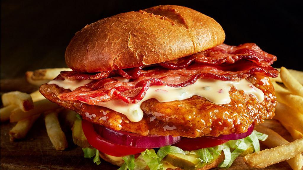 Ultimate Crispy Chicken Sandwich · Glazed with honey garlic sauce, topped with hardwood smoked bacon and cheddar cheese queso with lettuce, tomato, pickles, onion, and honey mustard.