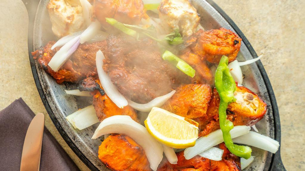 Tandoori Mixed Grill · A combination of our appetizing tandoori chicken, chicken tikka, malai chicken kabab, boti kabab, shrimp tandoori and fish tikka.