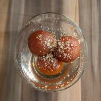 Gulab Jamun · Milk and cheese balls soaked in sweet syrup, served warm.