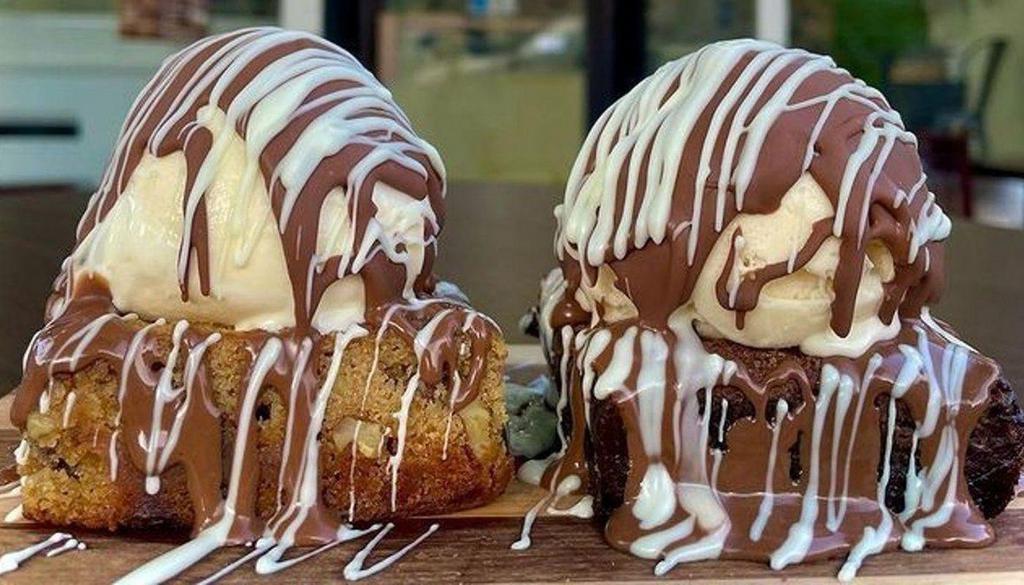 Blondie Brownie Sundae · Two scoops of ice cream, covered in milk chocolate and drizzled with white chocolate. (Blondie brownie has walnuts and pecans.).