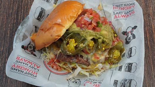 South Of The Burger · guacamole, caramelized onions, pepper jack cheese, queso sauce, chipotle aioli, pico de gallo, jalapeno, lettuce, tomato
