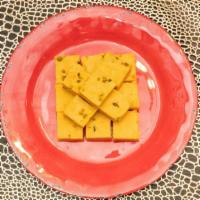 Mango Burfi (Like Halva) · Milk based dessert infused with a saffron mango puree, topped with baked pistachios. (Allerg...