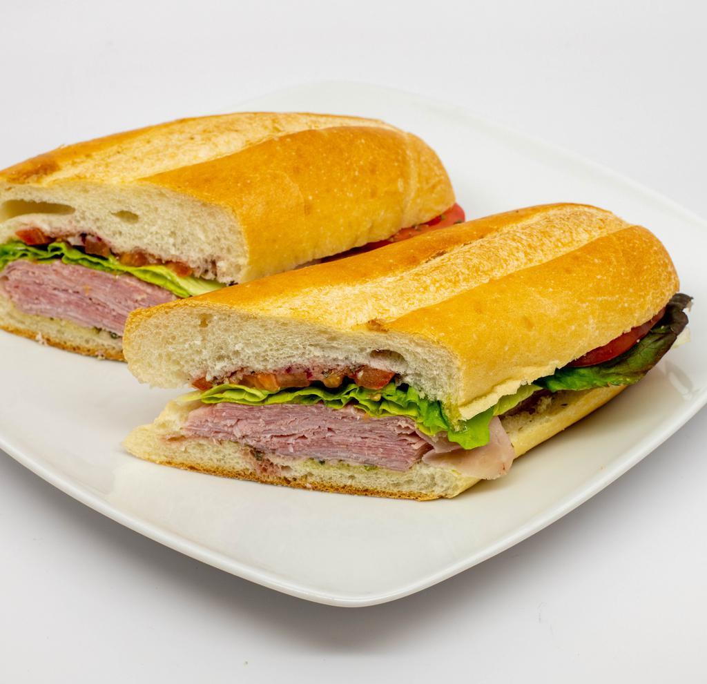 Italian Hero · Genoa salami, hot capicola, provolone cheese, tomatoes, green leaf lettuce, hot chopped peppers, red onions, olive oil, red wine vinegar and oregano on a hero roll.