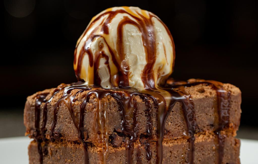 Triple-Stack Brownie · Chocolate ganache, vanilla & caramel cream, vanilla bean ice cream.
