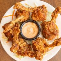 Lolly Pop Chicken · Pulled back chicken wings battered and fried to golden perfection served with a creamy sauce.