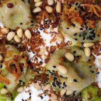 Shishbarak · Lebanese mushroom filled dumplings, warm yogurt, pine nuts, and spicy herb sauce.