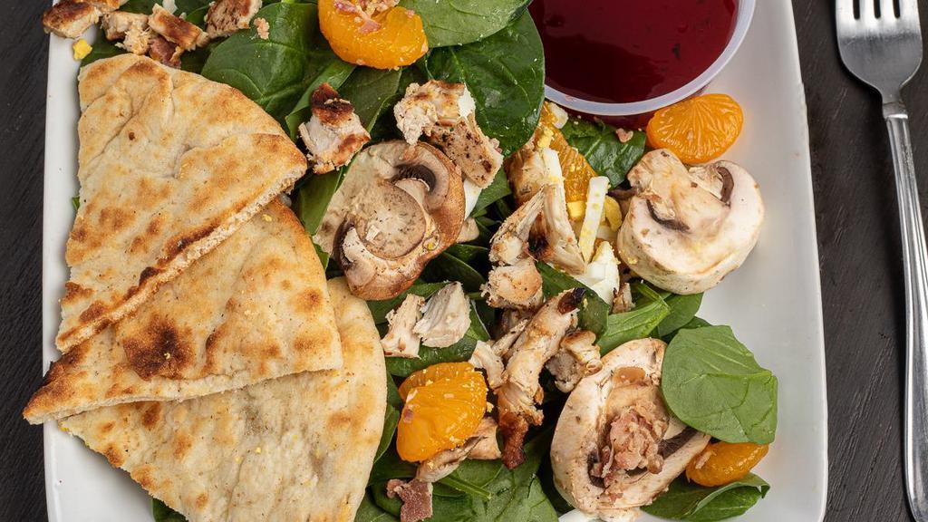 Spinach Salad · Fresh spinach topped with a charbroiled chicken breast, chopped egg, real bacon pieces, pieces, cucumbers, and mandarin oranges, served with pita points and a raspberry vinaigrette dressing.