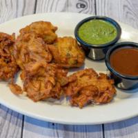 Onion Bhajia · Classic Indian Starter — Crispy chickpea battered pomegranate & Onion fritters.