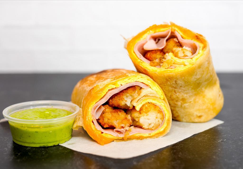 Ham, Egg, & Cheddar Burrito  · 3 fresh cracked, cage-free scrambled eggs, melted Cheddar cheese, sliced ham, and crispy potato tots wrapped in a toasted 12” flour tortilla. Comes with avocado salsa verde side.