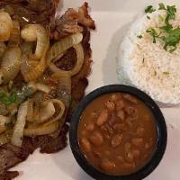 Bistec Encebollado (Steak With Sautéed Onions) · Served with rice, beans and tortillas.