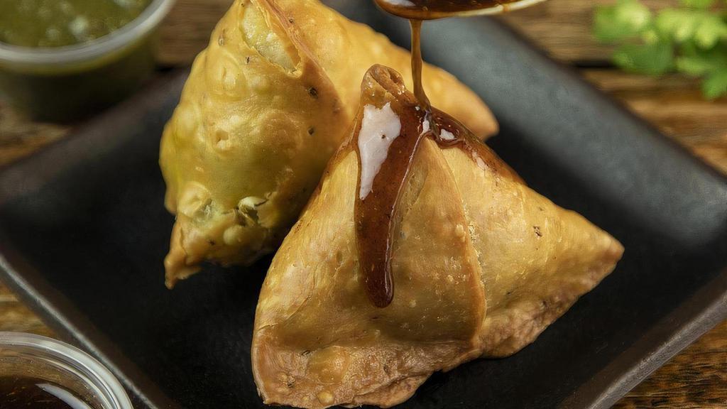 Vegetable Samosa · Vegetable Samosas are Indian snacks with delicious pockets of dough stuffed with a potato mixture and spices, deep fried. Served with tangy tamarind sauce.
