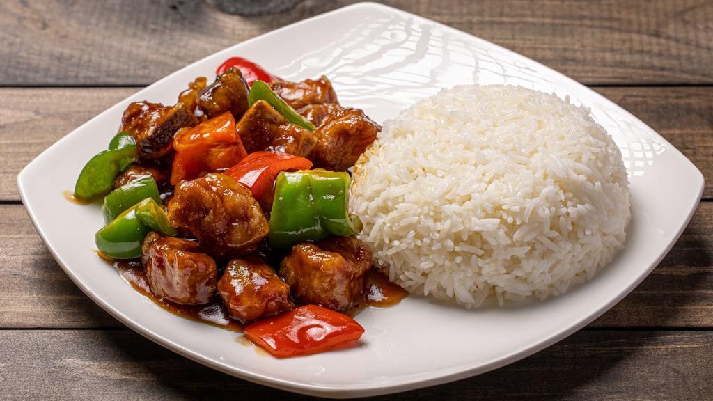 Sweet & Sour Pork Rib Over Rice / 糖醋排骨飯 · Pork ribs are deep fried and glazed with sweet and sour sauce. Served with rice. Ingredients: pork ribs, bell pepper, and rice.
