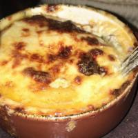 Artichoke Moussaká · Layers of artichoke, potato, cheese, roasted leeks and onions, topped with béchamel.