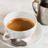 Americano · Espresso in a cappuccino cup with a small pitcher of hot water.