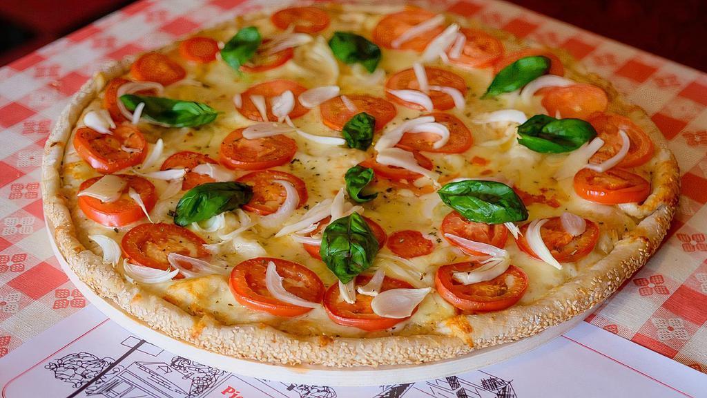 Tomato Basil Onion Pizza · Traditional Neapolitan style sauce less pizza topped with sliced tomato, onion, fresh garlic, basil, and mozzarella cheese.