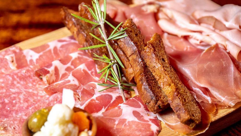 Italy Vs Spain · Sliced serrano ham vs Parma prosciutto with honey ricotta and house marinated olives.