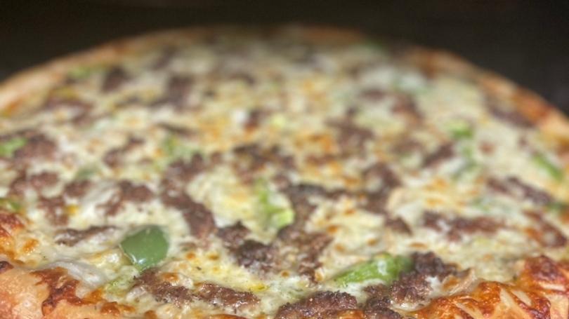 Steak Philly Pizza · garlic sauce, shaved Philly steak, onion, green pepper, mushroom and mozzarella. Topped with steak seasoning.